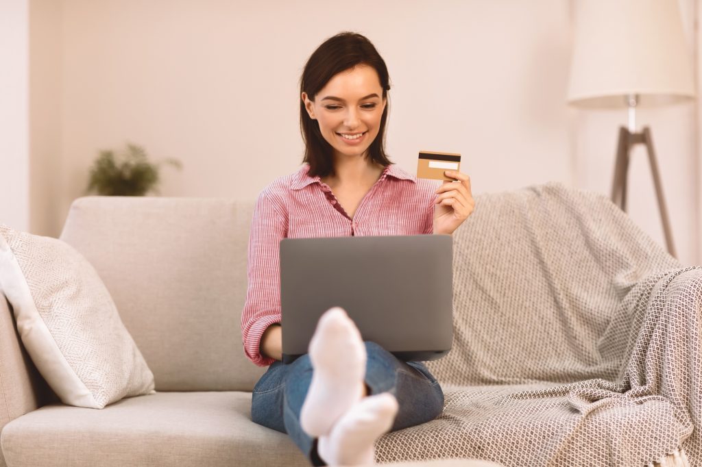 Young woman making purchases sitting on the couch